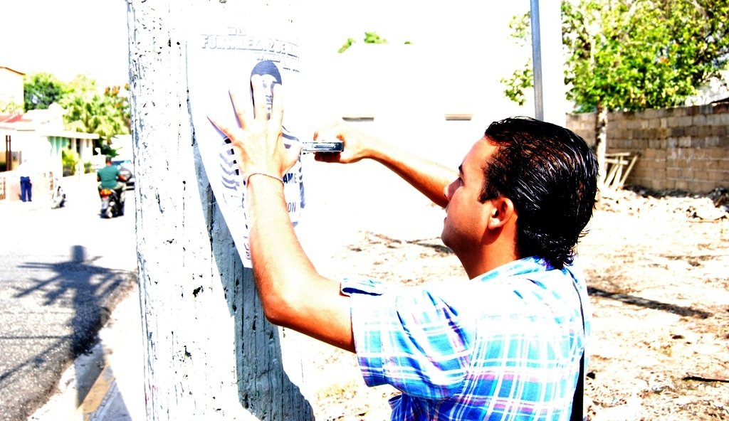 Alexander Jerez en las calles pega afiche No a la Carcel 2 de mayo